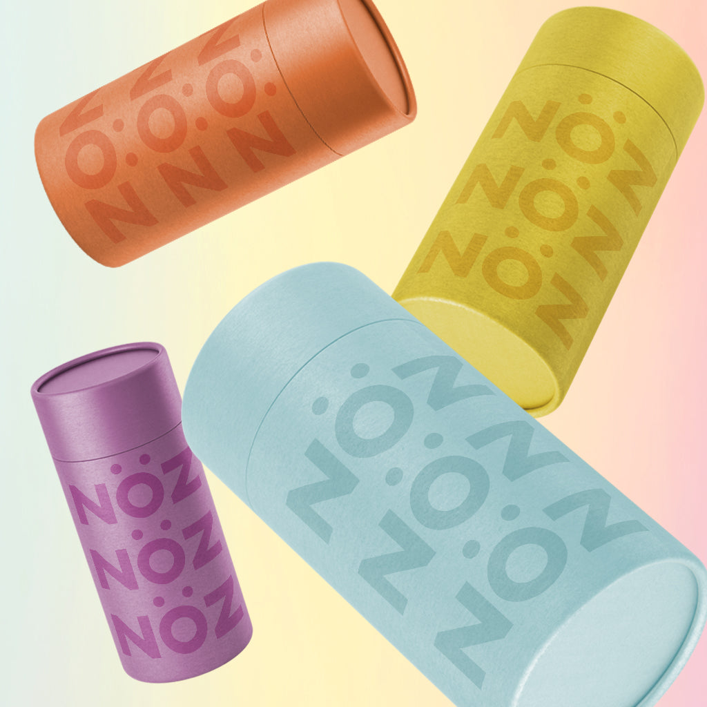 Four variants of NOZ sunscreen in a stick. Purple, blue, yellow, orange.